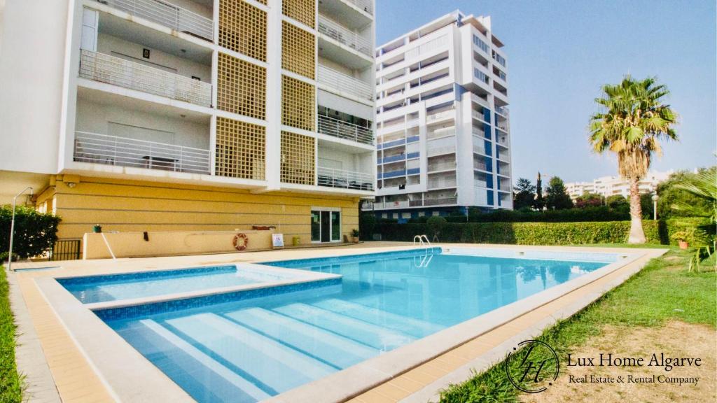 einem Pool vor einem Gebäude in der Unterkunft Alegria - Shopping Center 150m - Pool - Parking - Terrace in Portimão