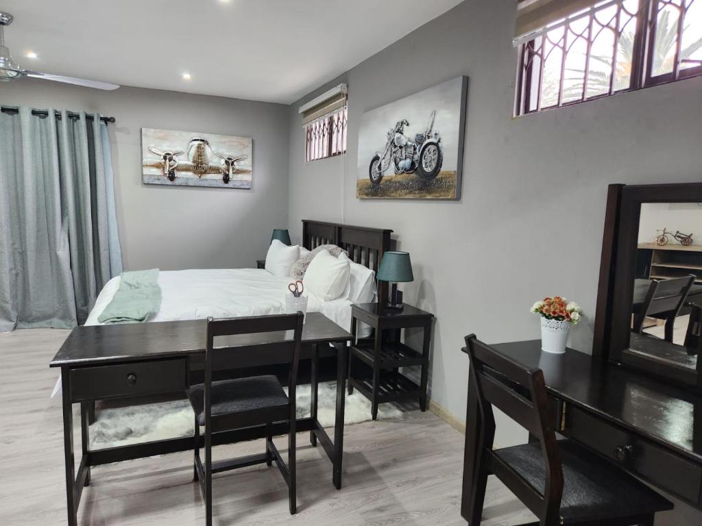 1 dormitorio con cama, escritorio y mesa en Gabriel's Gate, en Johannesburgo