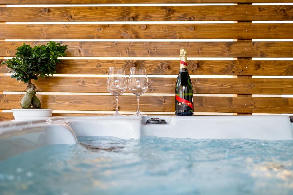 Una botella de champán y dos copas de vino junto a una bañera. en Sciaraqa, en Mazara del Vallo