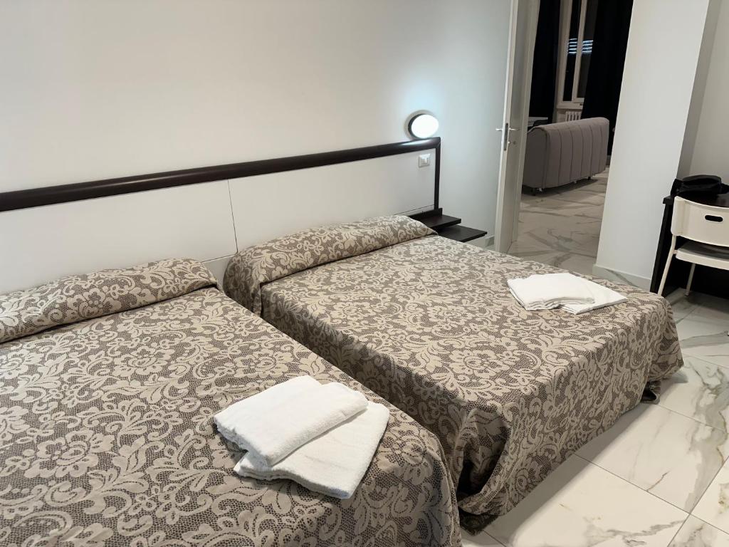 duas camas num quarto de hotel com toalhas em Jcube Apartments Bocconi Milano em Milão