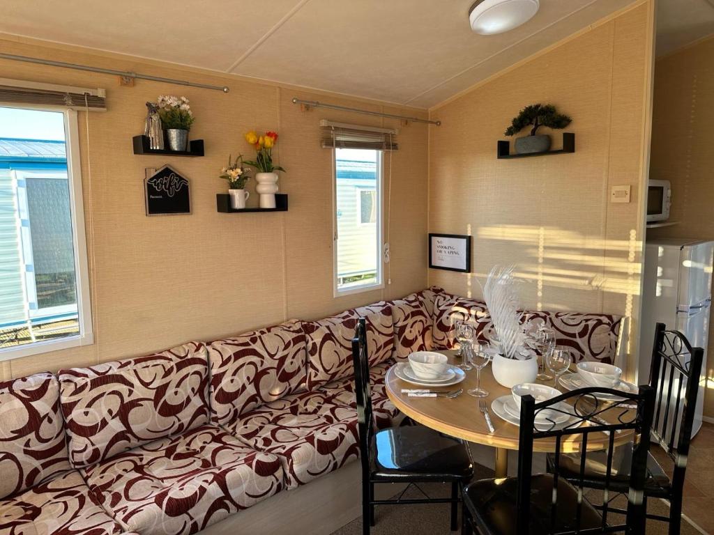 een woonkamer met een bank en een tafel bij CaSa VistA - Holiday Home On The Beach in Clacton-on-Sea