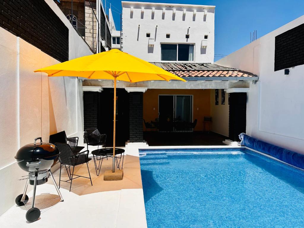 un parasol jaune assis à côté d'une piscine dans l'établissement Casa Rinconcito Del Sol Con Alberca, à Tonatico