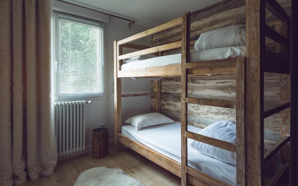 a bedroom with two bunk beds and a window at Rock Noir & Spa in La Salle-les-Alpes
