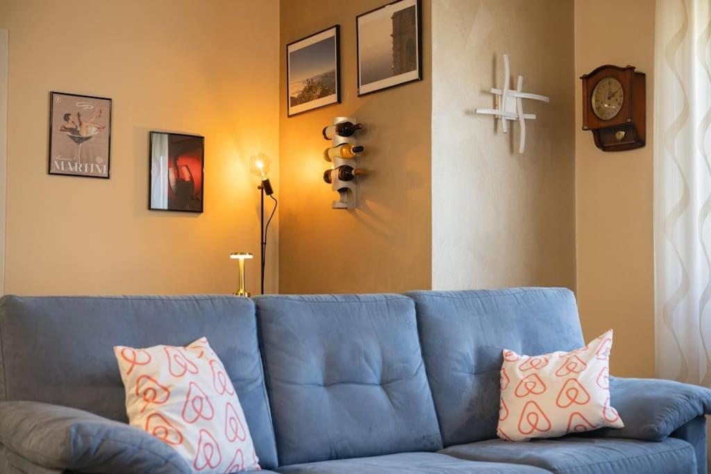 - un canapé bleu avec des oreillers dans le salon dans l'établissement Casa Gozza, à Verzuolo