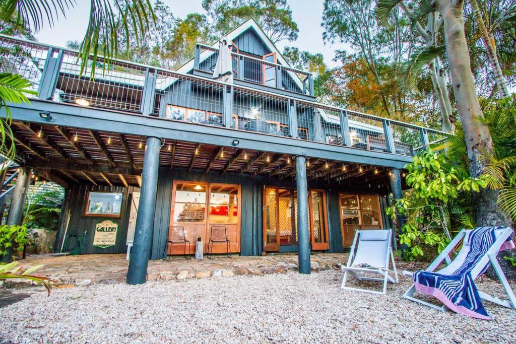 a house with a deck and two lawn chairs at The Gallery - Beach hideaway in stunning 1770 in Seventeen Seventy