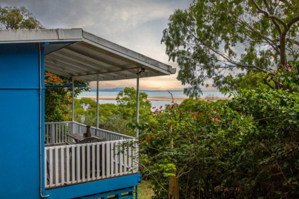 a balcony of a house with a view of the ocean at Sunset Villa - Pet-friendly cottage in 1770 in Seventeen Seventy