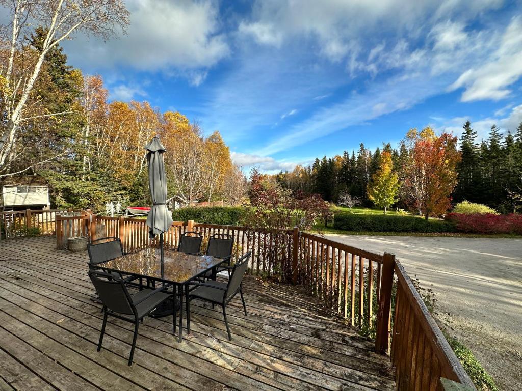 a table and chairs on a wooden deck with an umbrella at Eden Estate B&B in Reidville