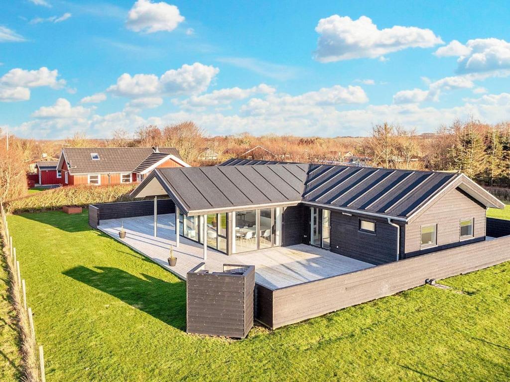 a house with a large deck in a field at Modern Cottage with Spa - By Traum Ferienwohnungen in Vinderup
