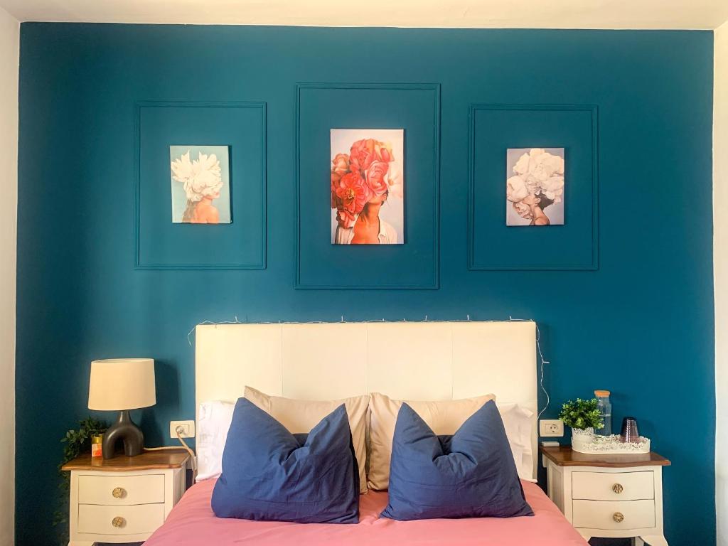 sypialnia z niebieskimi ścianami i łóżkiem z niebieskimi poduszkami w obiekcie Habitaciones privadas cerca de la playa y aeropuerto en casa compartida con otros huéspedes w mieście Playa Honda