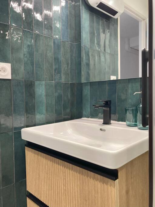 a bathroom with a sink and a mirror at Tropical Duplex : Bord de mer + Piscine in Frontignan