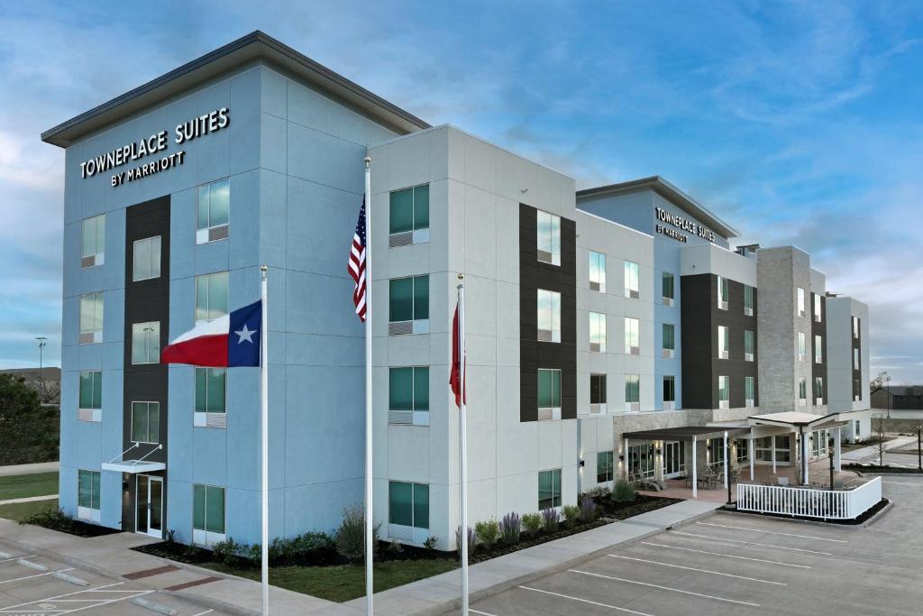 un hotel con dos banderas en un estacionamiento en TownePlace Suites by Marriott Abilene Southwest, en Abilene