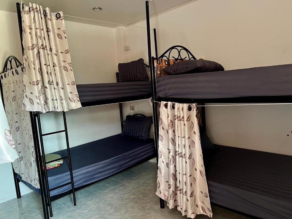 a room with three bunk beds in a room at Star Dormitory in Haad Rin