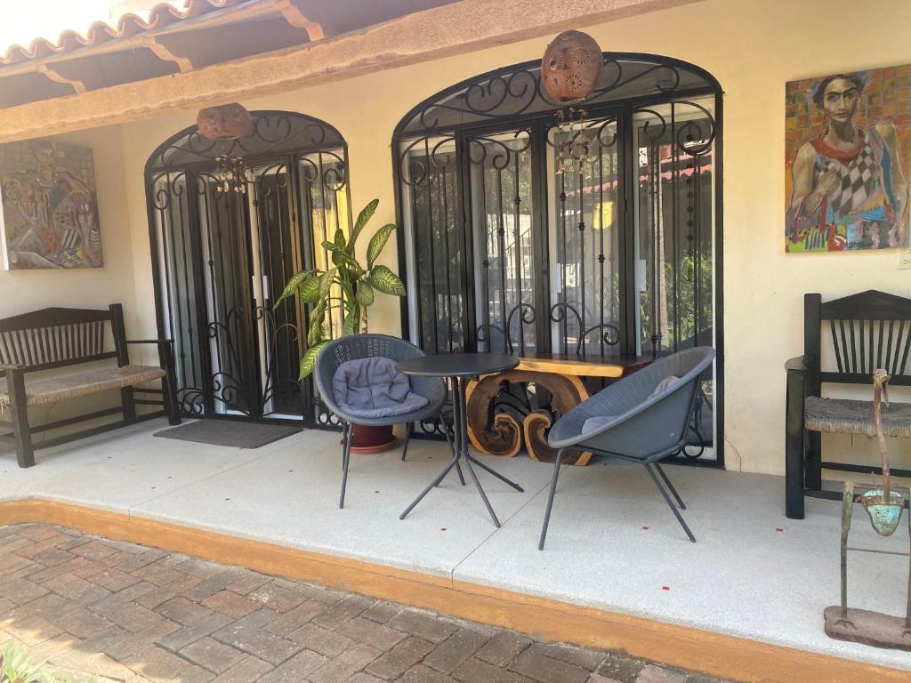 un patio con puertas de hierro, mesa y sillas en Casita del Artista, en San Patricio Melaque