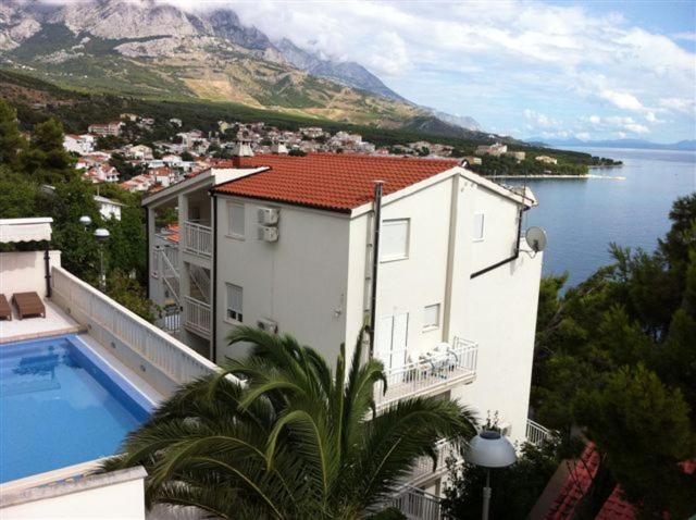 a house with a swimming pool next to a body of water at Villa Maja original since 2005 in Baška Voda