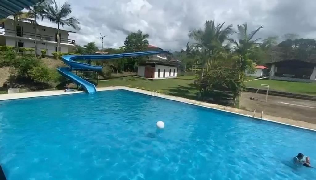 - une piscine dans un complexe avec un toboggan bleu dans l'établissement HOTEL RANCHO PLAYA DEL SOL, à Pedernales