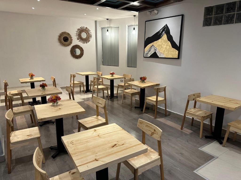 a restaurant with wooden tables and chairs in a room at CASA CRISTOBAL Centenario in Cusco