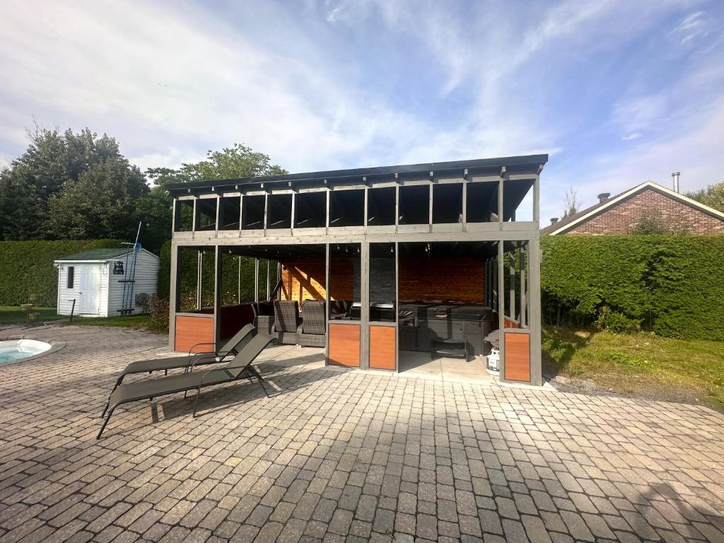 - un pavillon avec un banc sur une terrasse dans l'établissement L'Oasis Urbaine, à Saint-Hubert