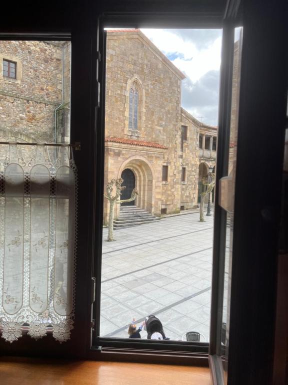 una ventana con un gato mirando fuera de un edificio en APARTAMENTO TURÍSTICO SAN NICOLAS, en Avilés
