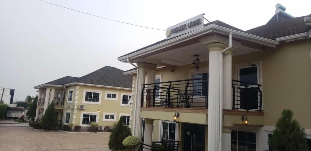 a large yellow house with a balcony at FOKUZZY LODGE in Accra