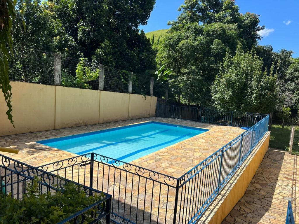 a swimming pool with a fence around it at Pousada dos Girassóis in Conservatória