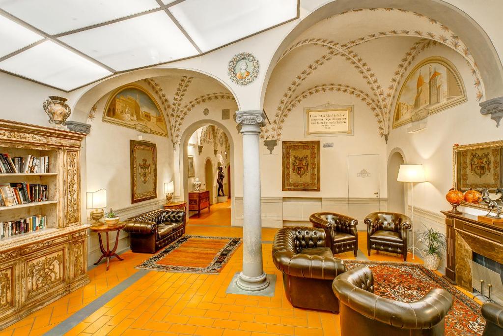 sala de estar amplia con sillas y chimenea en Firenze Suite, en Florencia