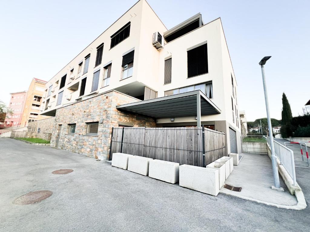 a white building with a fence in front of it at Zoela in Izola
