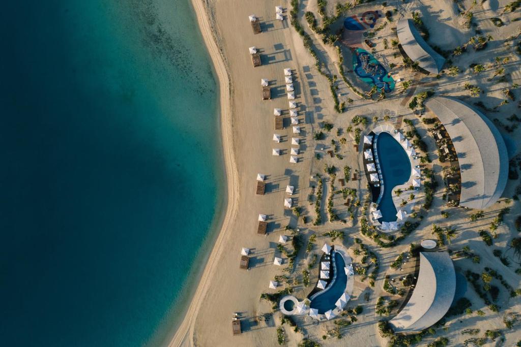 an overhead view of a beach with a group of resorts at The St. Regis Red Sea Resort in Ḩanak