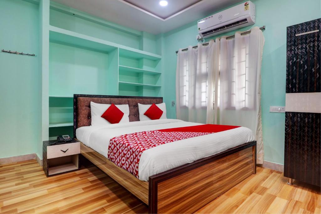 sypialnia z łóżkiem z czerwonymi poduszkami w obiekcie OYO Flagship S Grand Residency w mieście Hajdarabad