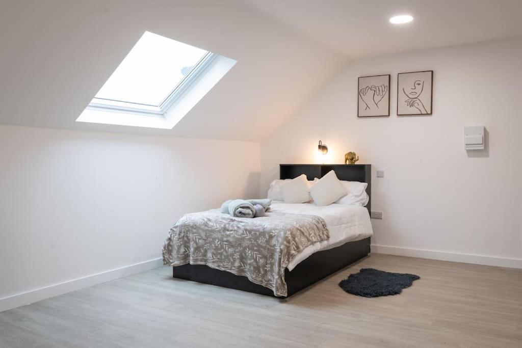 a white bedroom with a bed and a skylight at Stylish Central One Bed Studio in Manchester