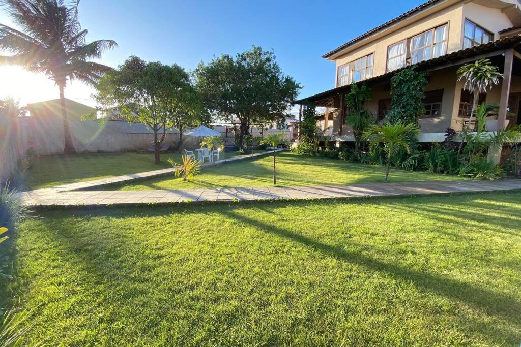una casa con un patio de césped al lado de un edificio en La Famille - Casa de Praia I Arraial do Cabo, en Arraial do Cabo