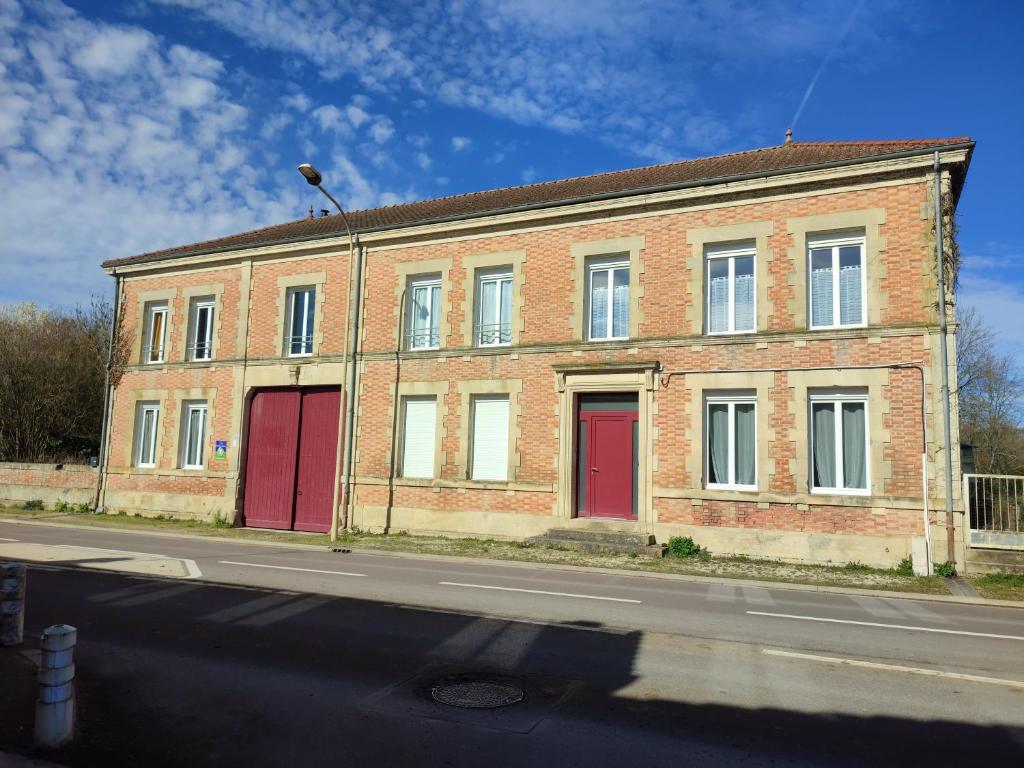 un edificio de ladrillo con puertas rojas en una calle en La Rose Paisible, en Brusson