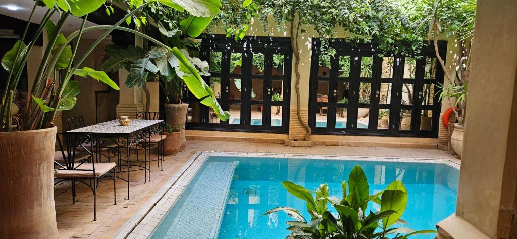 a swimming pool with a table and chairs and a table and a table at Riad Dar Haven in Tamraght Ou Fella