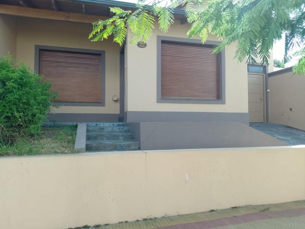 uma casa com duas janelas e uma entrada em La Soñada em Tandil