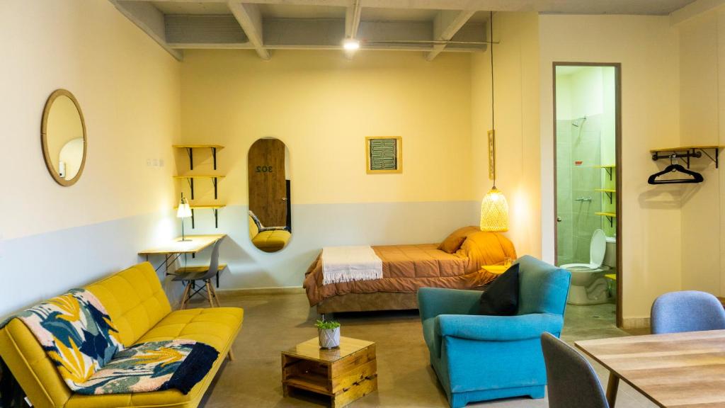 een woonkamer met een bank en een bed bij Casa Selva in Medellín