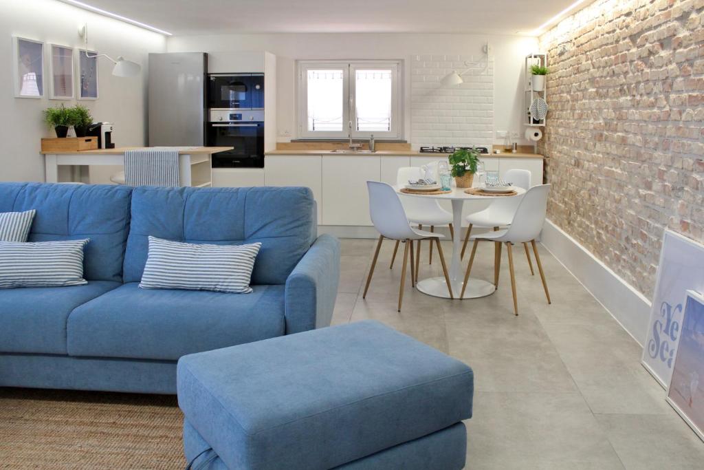 uma sala de estar com um sofá azul e uma mesa em BLUE HOUSE A casa di Tatta - apartments by the sea em Francavilla al Mare