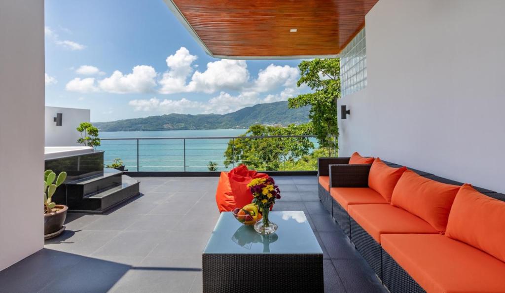 a living room with orange furniture and a view of the water at Atika Villa Patong in Patong Beach