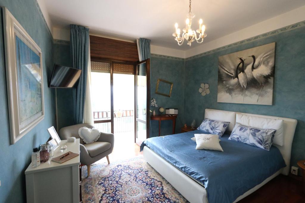 een blauwe slaapkamer met een bed en een stoel bij casa Monia in Roe
