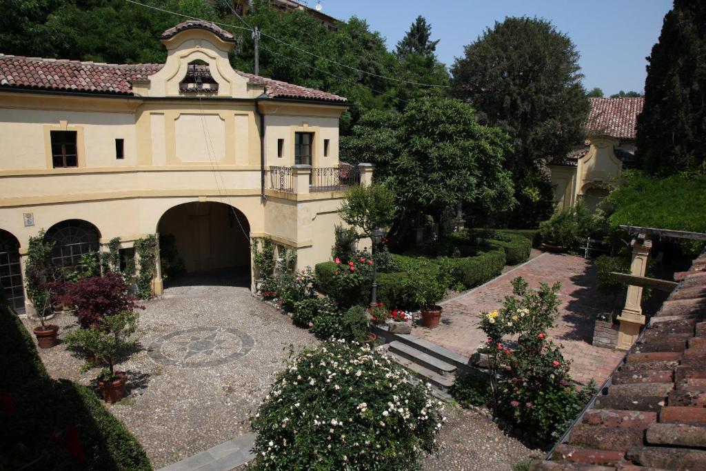 an old house with a courtyard with flowers at Palazzo Tornielli in Mombello Monferrato