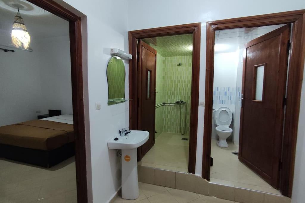 a bathroom with a sink and a shower and a toilet at Warzazat Apartments in Ouarzazate