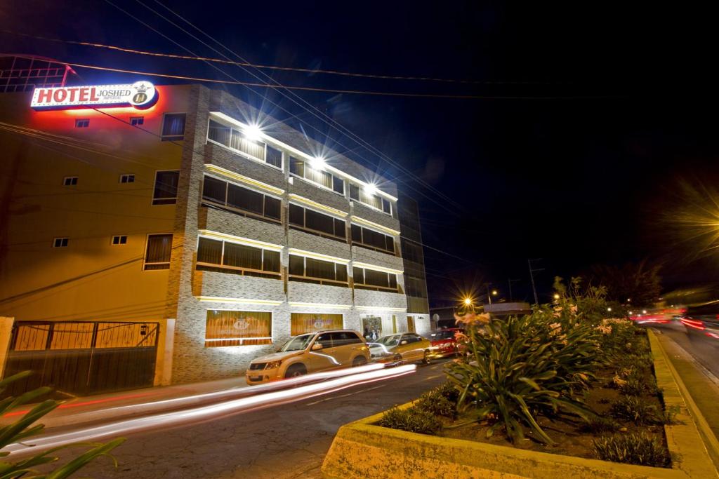 un hotel di notte con auto che guidano lungo la strada di Hotel Joshed Imperial a Latacunga