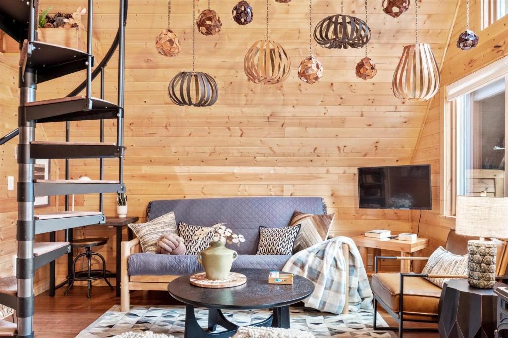 a living room with a blue couch and wooden walls at Perch - Boho Getaway in Ashford