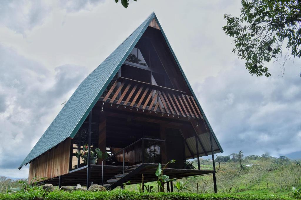 ein dreieckiges Haus mit grünem Dach in der Unterkunft Quinta Túru in La Colonia