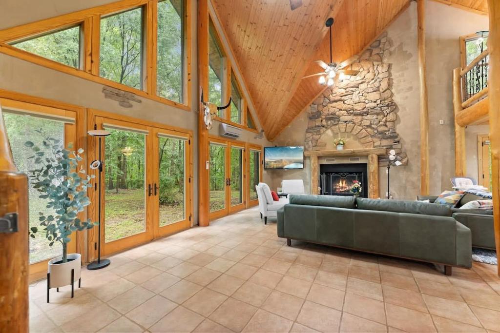 a living room with a couch and a stone fireplace at Private Cabin at Lake Hartwell in Townville