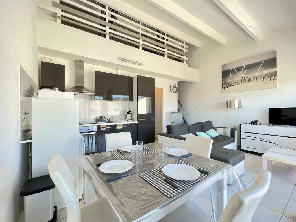 une salle à manger et une cuisine avec une table et des chaises dans l'établissement Superbe 2 pièces à 200m de la plage avec terrasse et parking - FR-1-338-533, à Sète