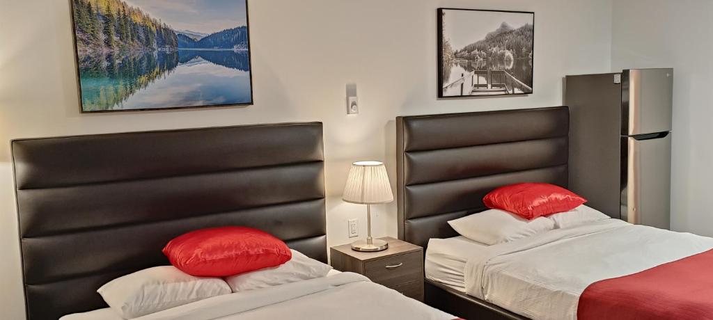 Duas camas com almofadas vermelhas num quarto em Mountain View Hope Motel em Hope