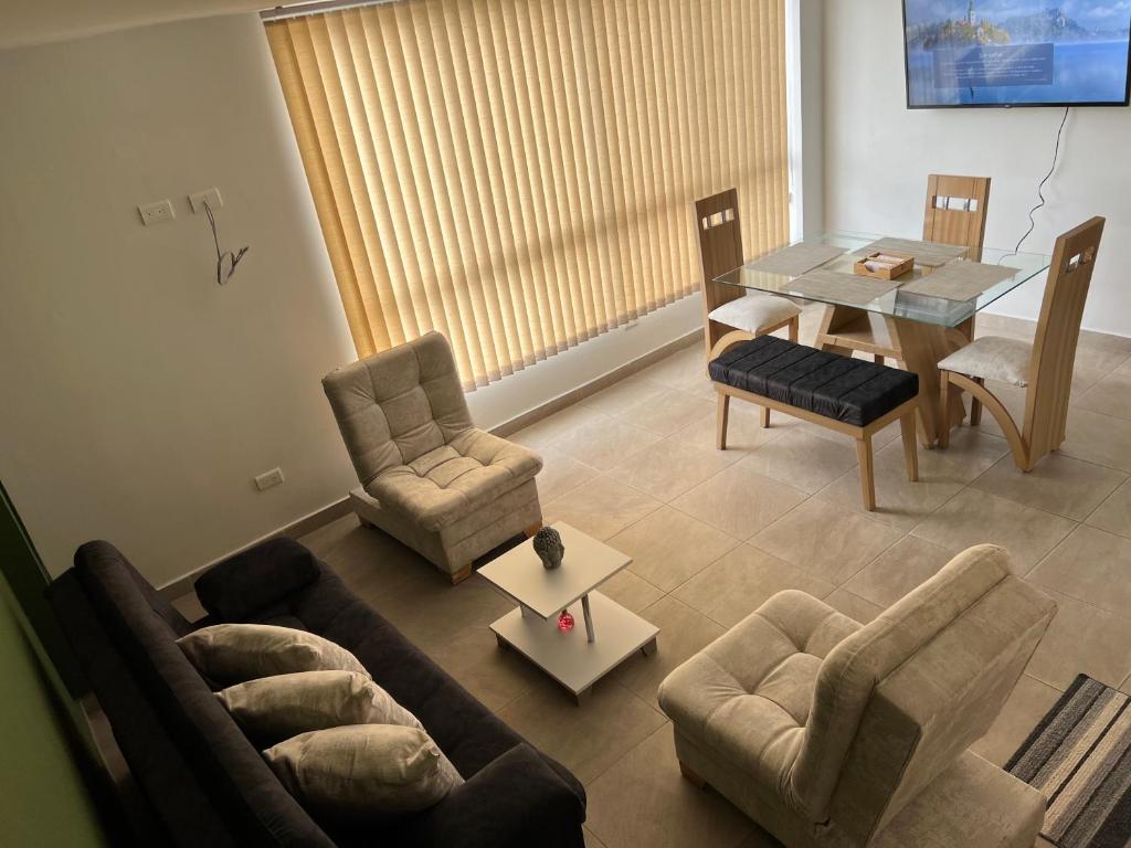 uma sala de estar com um sofá, uma mesa e cadeiras em Lujoso apartamento central y moderno em Manizales