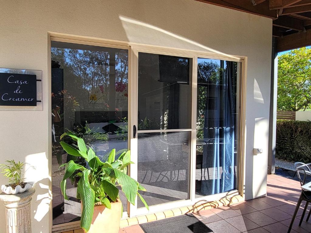 uma porta de vidro de correr aberta de uma casa com um pátio em Beachside One Bedroom Flat Retreat em Maroochydore