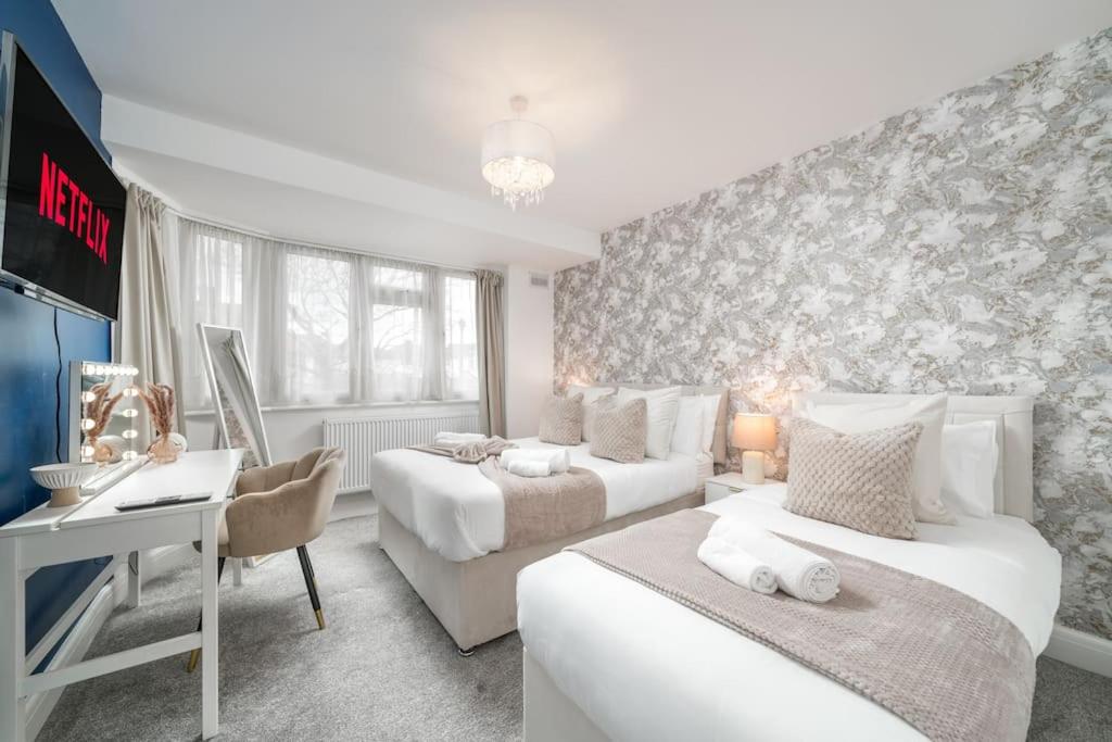 a bedroom with two beds and a desk with a computer at Deluxe House W/Parking & Garden Near Wembley - Sleeps 8 in Harrow Weald