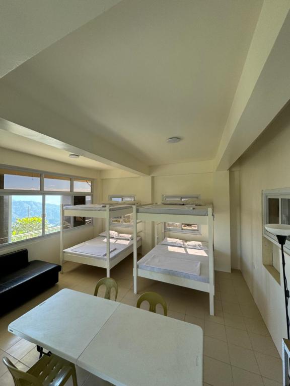 Pokój z 2 łóżkami piętrowymi i stołem w obiekcie Baguio-itogon mountain view w mieście Itogon