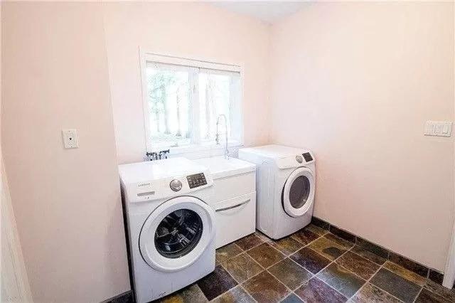 a laundry room with a washing machine and a window at Charming Affordable Accommodation 20 min to Toronto P3 in Pickering